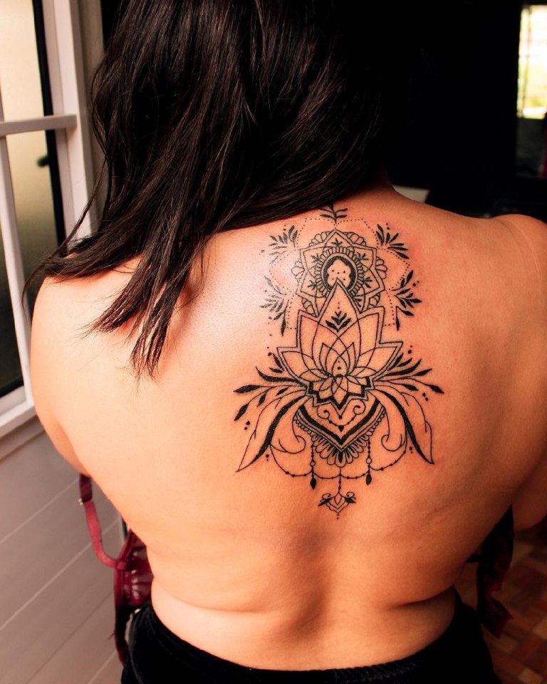 Татуировка мандала на спине у девушки